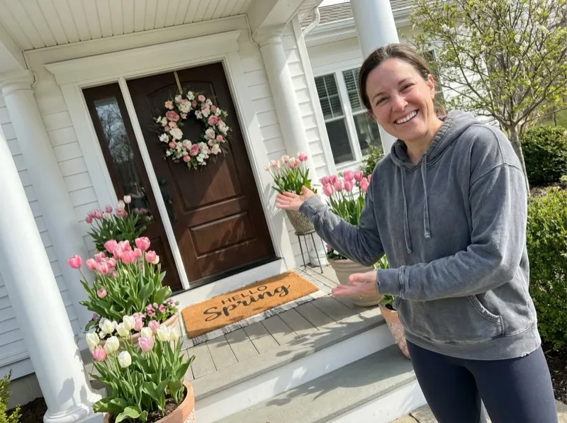 Woman proudly showing off her spring porch decorating work